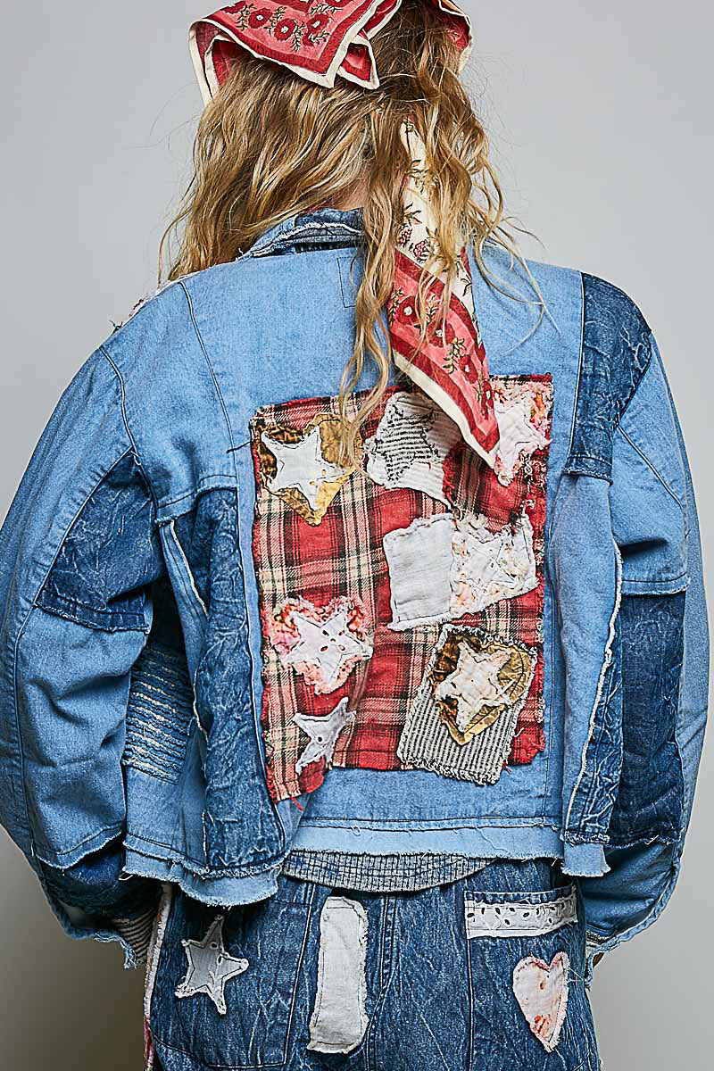 Back view of blue patchwork denim jacket with red plaid fabric panel and handcrafted appliqué details