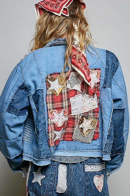 Back view of blue patchwork denim jacket with red plaid fabric panel and handcrafted appliqué details