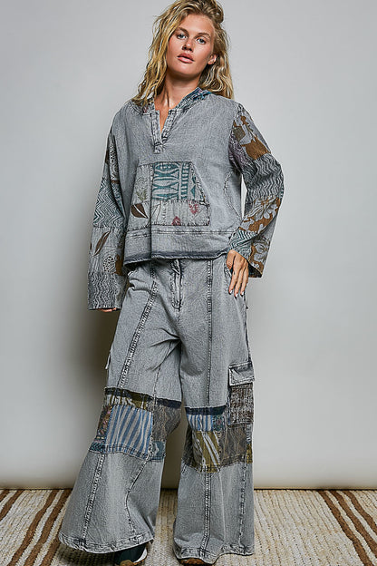 Model wearing relaxed grey wide-leg pants with mixed printed patchwork panels