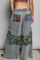 Grey wide-leg pants with mixed printed patchwork panels and utility pockets, back view