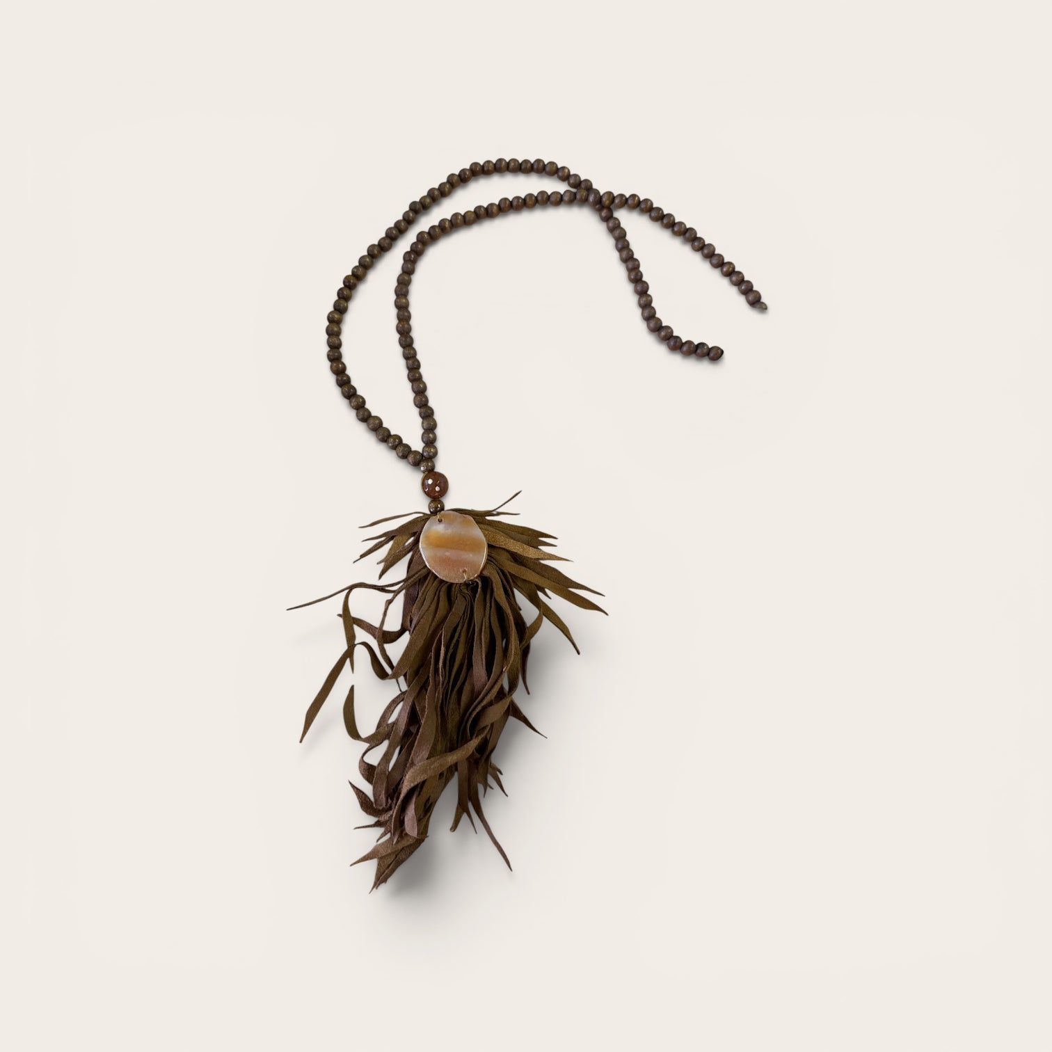 Brown wooden bead with fringe and stone