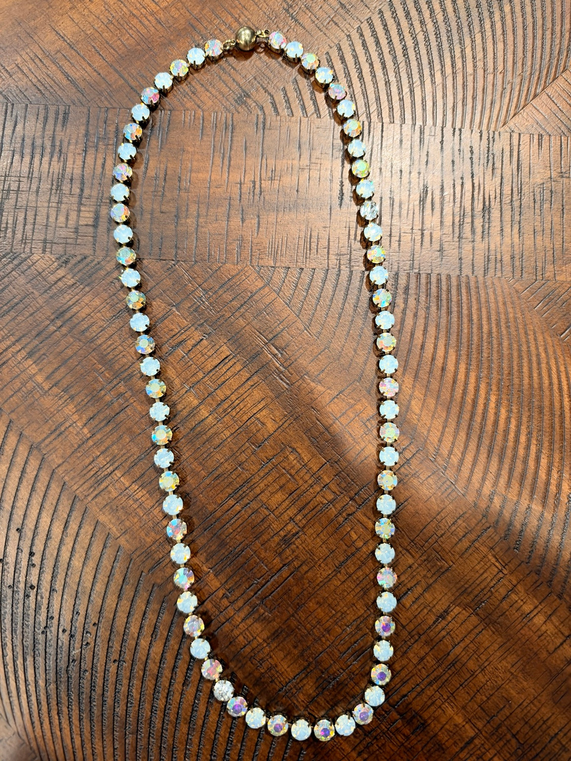 Alice Opal Glow necklace with alternating white opal-look and iridescent round stones in gold-tone settings, clasp at top