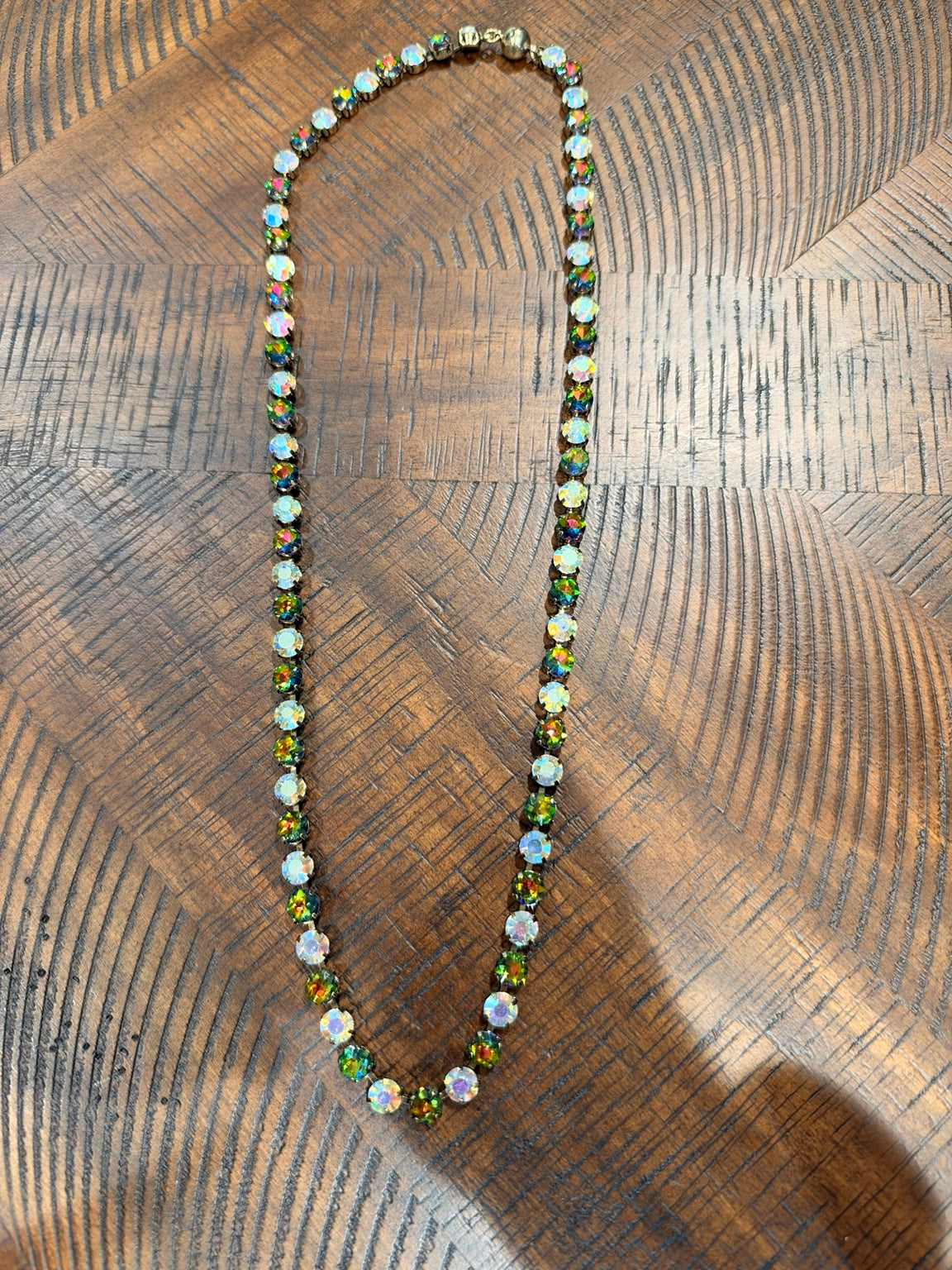 Alice necklace with alternating iridescent and dark rainbow round stones, clasp at top