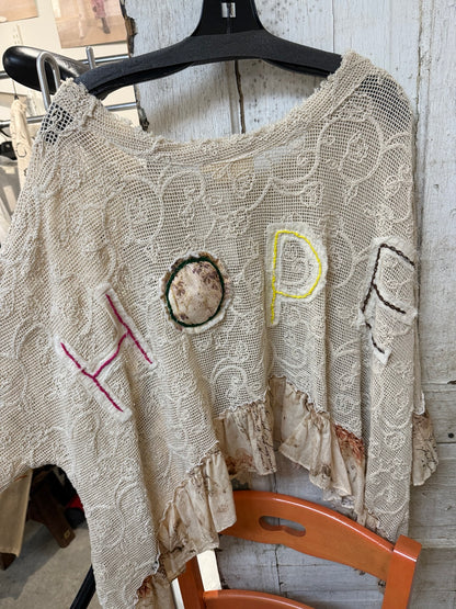 Back of Paper Lace Tea Dye Hope Shirt with large HOPE appliqué letters and printed ruffle hem