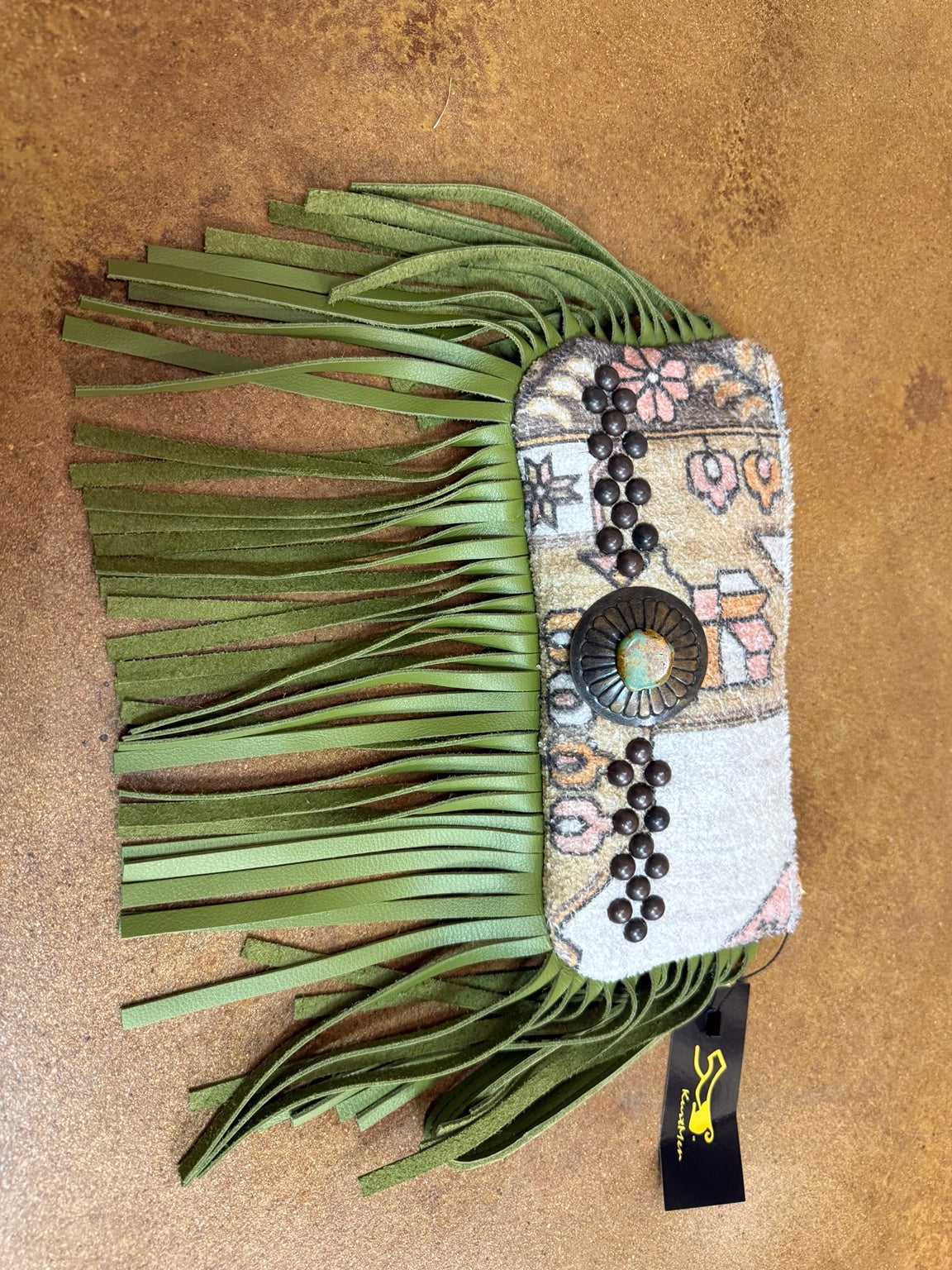 Kurtman patterned clutch with olive green fringe, dark studs and turquoise-colored concho