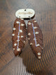 A Rare Bird Cowhide Rhinestone Feather Earrings on branded wooden card