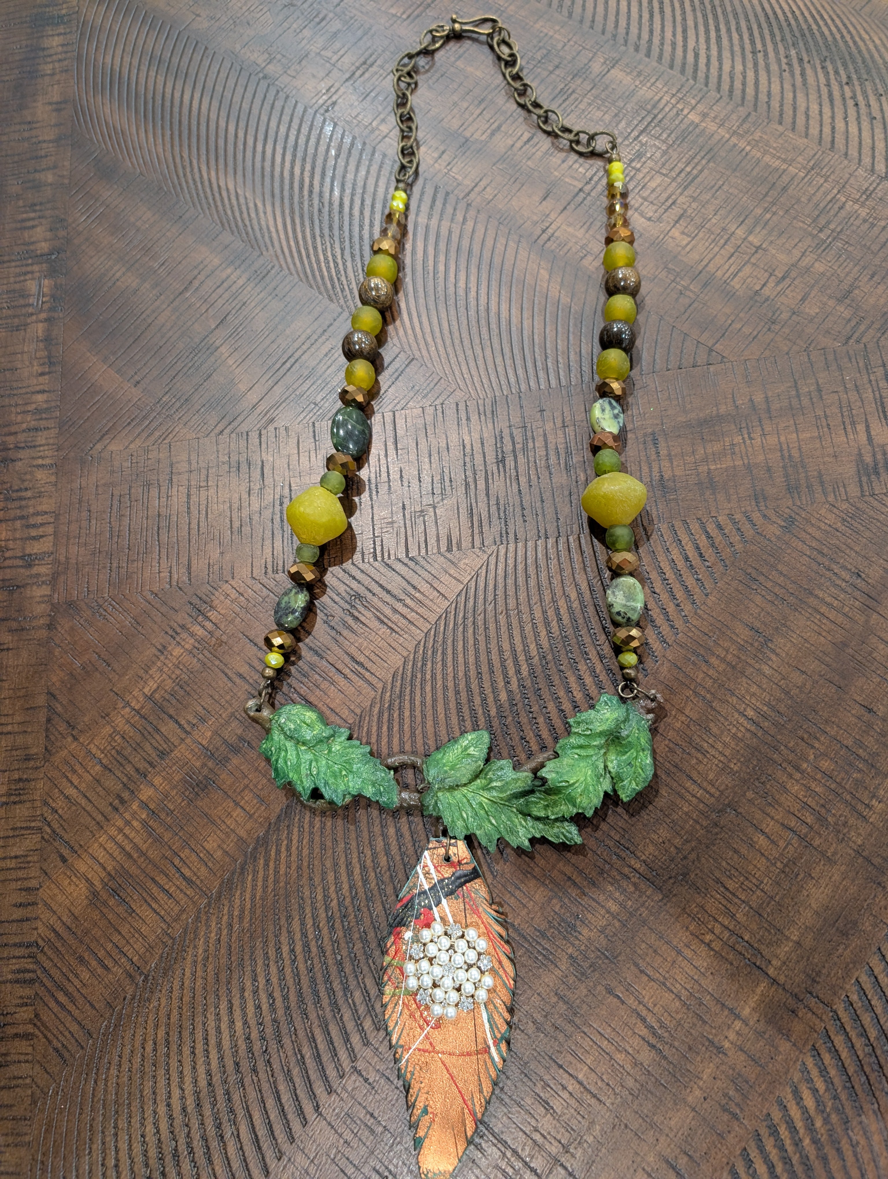 A Rare Bird Earthen Leaf and Feather Pendant Necklace with mixed green bead strand