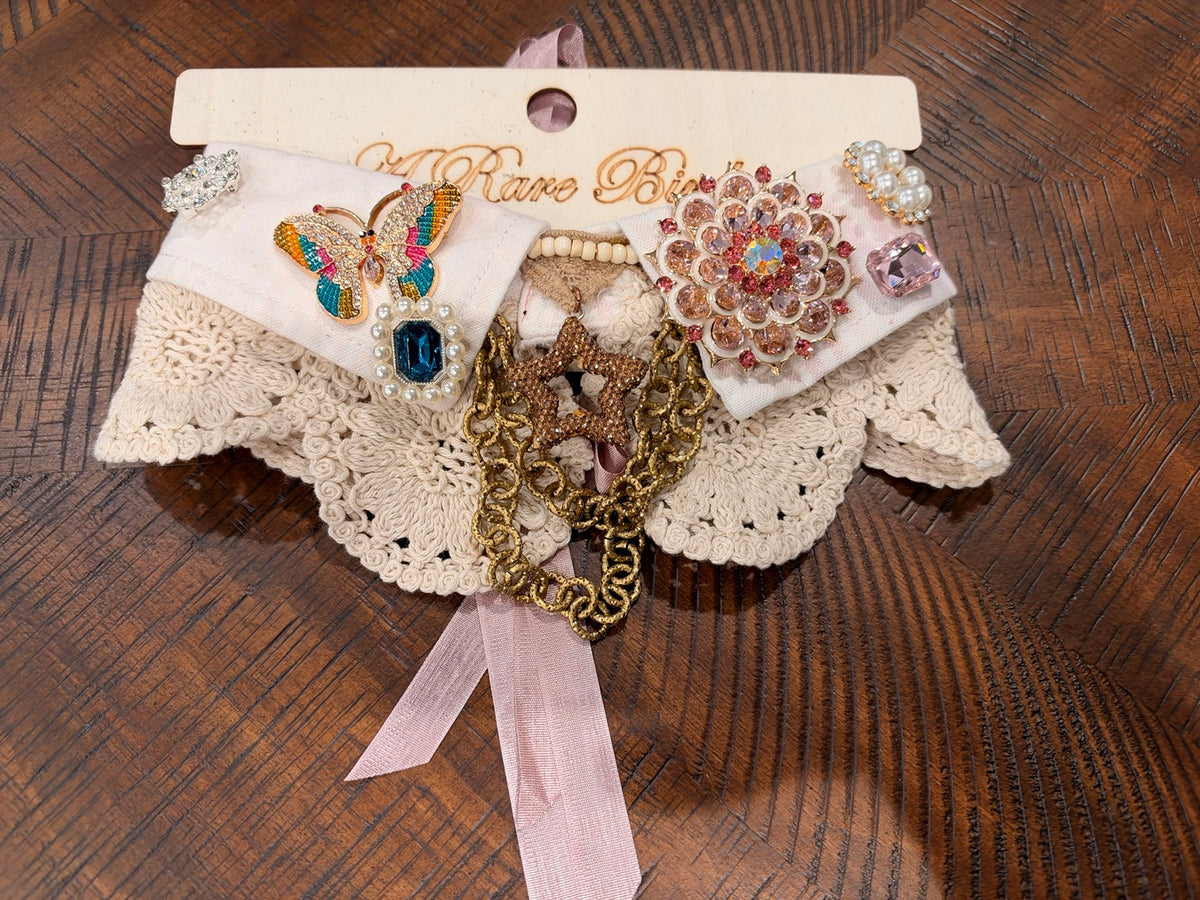 Ivory with a colorful butterfly, blush floral medallion, teal gem, and pearl-look accents.