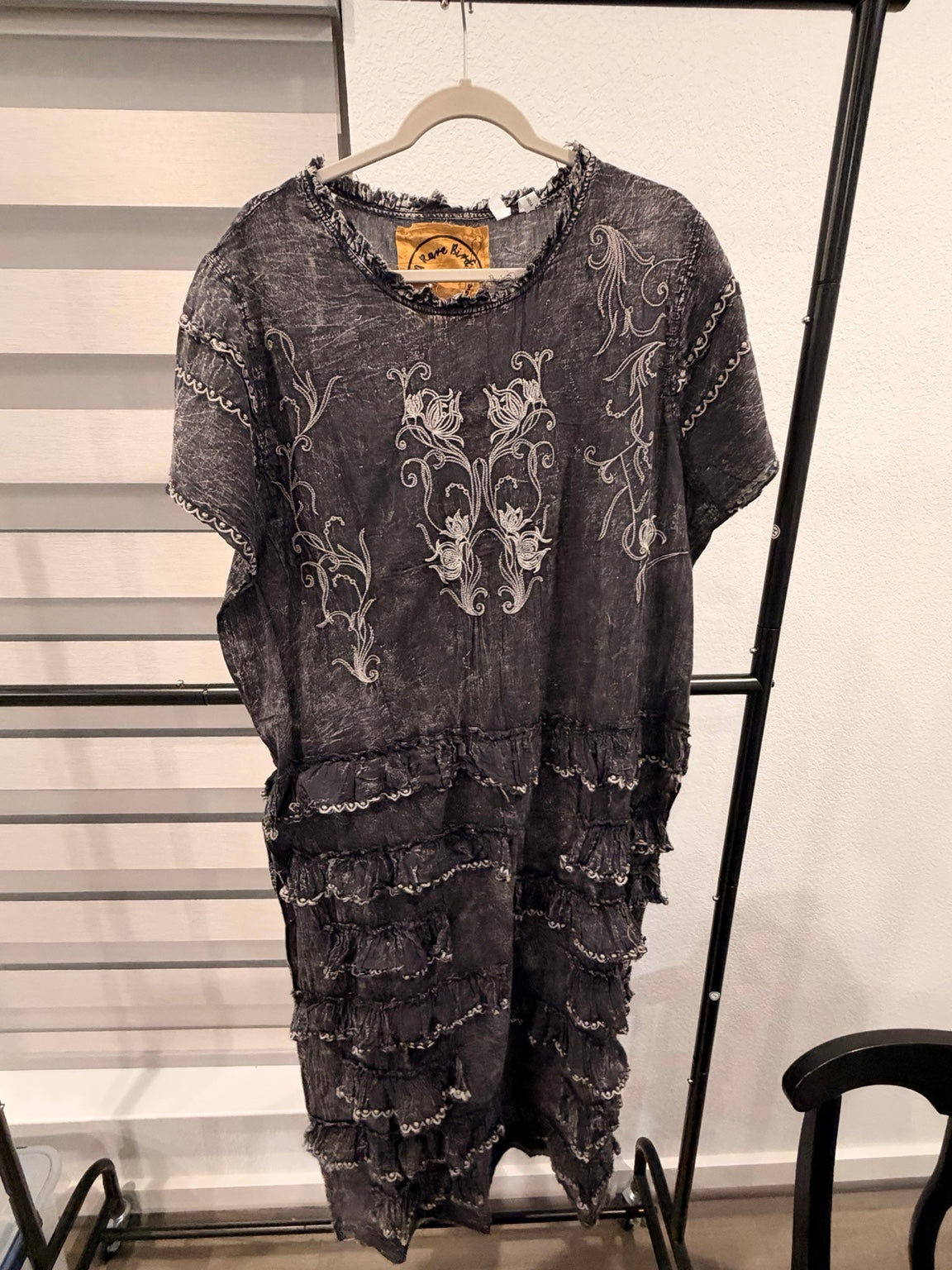 A Rare Bird washed charcoal dress with cream floral embroidery, short sleeves, and layered ruffle skirt