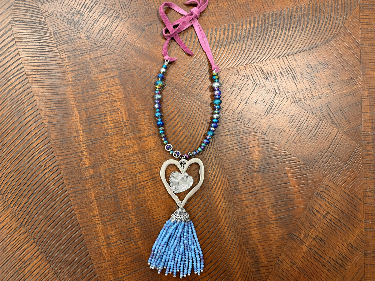 A Rare Bird Heartstrings necklace with blue beaded tassel, silver-tone hearts and purple ties