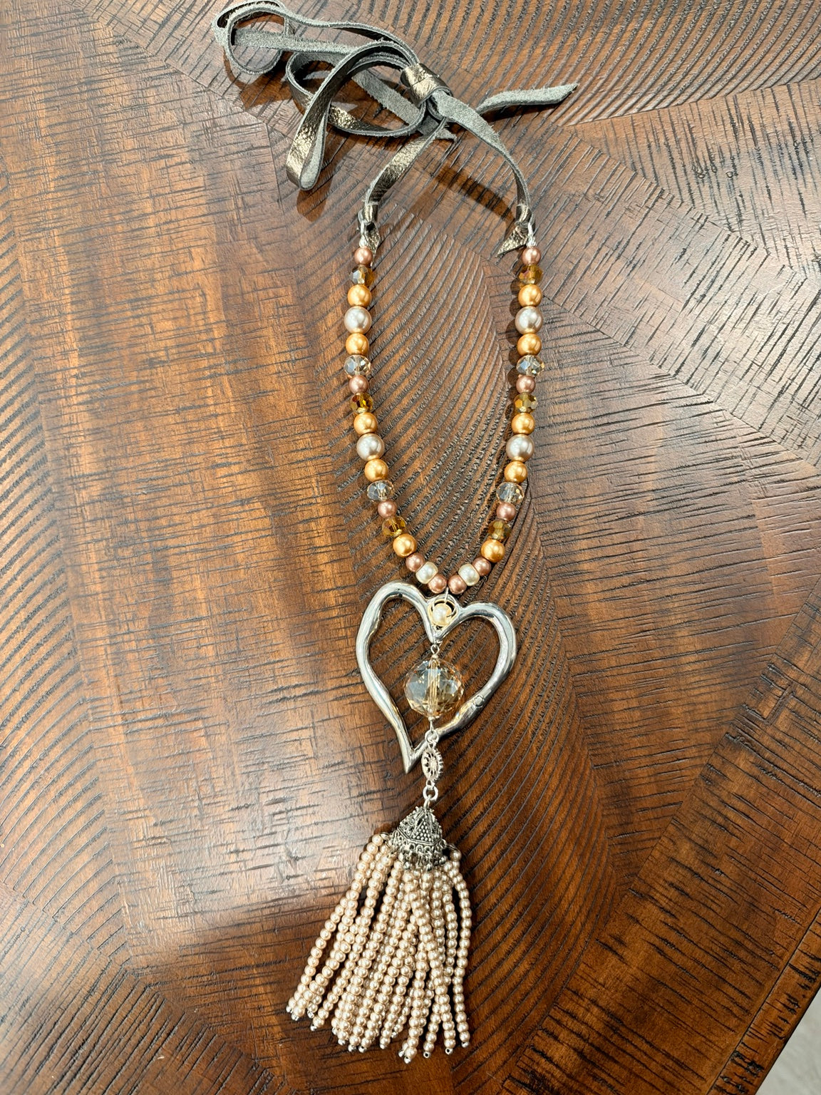 A Rare Bird Heartstrings necklace with silver-tone open heart and champagne beaded tassel
