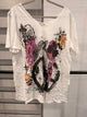 A Rare Bird white V-neck graphic tee with an angel, pink wings, crosses, and floral accents