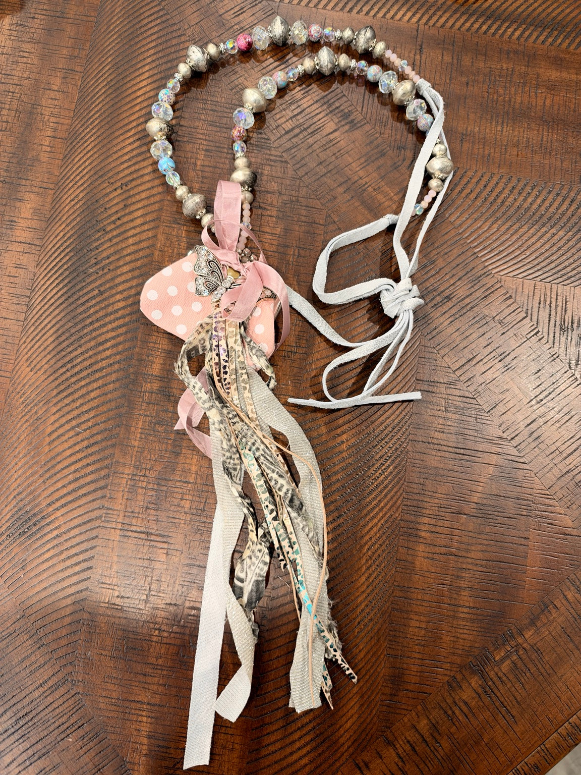 A Rare Bird pink polka dot coin purse necklace with butterfly accent and ribbon fringe