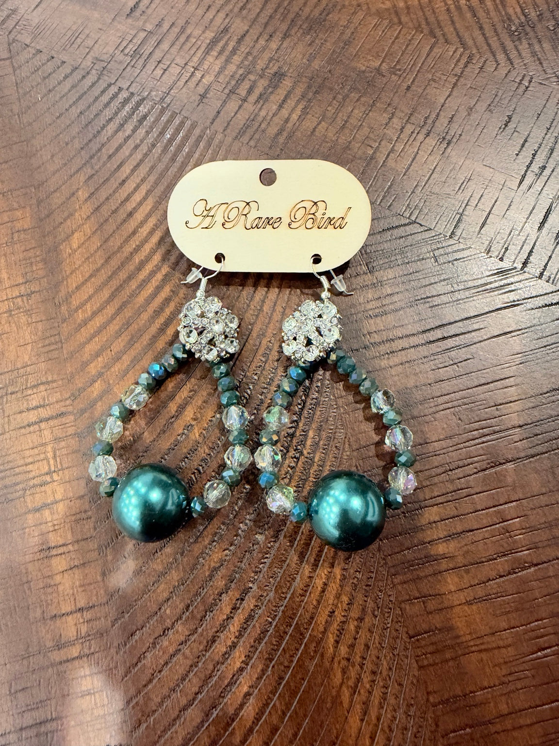 A Rare Bird teal beaded teardrop earrings with large lustrous teal beads and sparkling floral tops