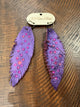 Purple feather-shaped earrings with pink rhinestone accents