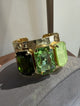 WaFa Emerald Trio Cuff Bracelet — three emerald-cut crystals in olive, mint, and peridot on a hammered gold-tone cuff