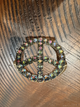 Upright gold-tone peace sign bracelet with smoky iridescent stones