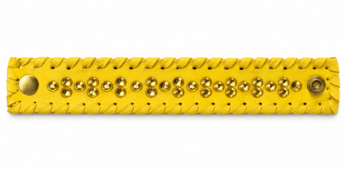 Yellow cuff with golden faceted stones and yellow whipstitched edges