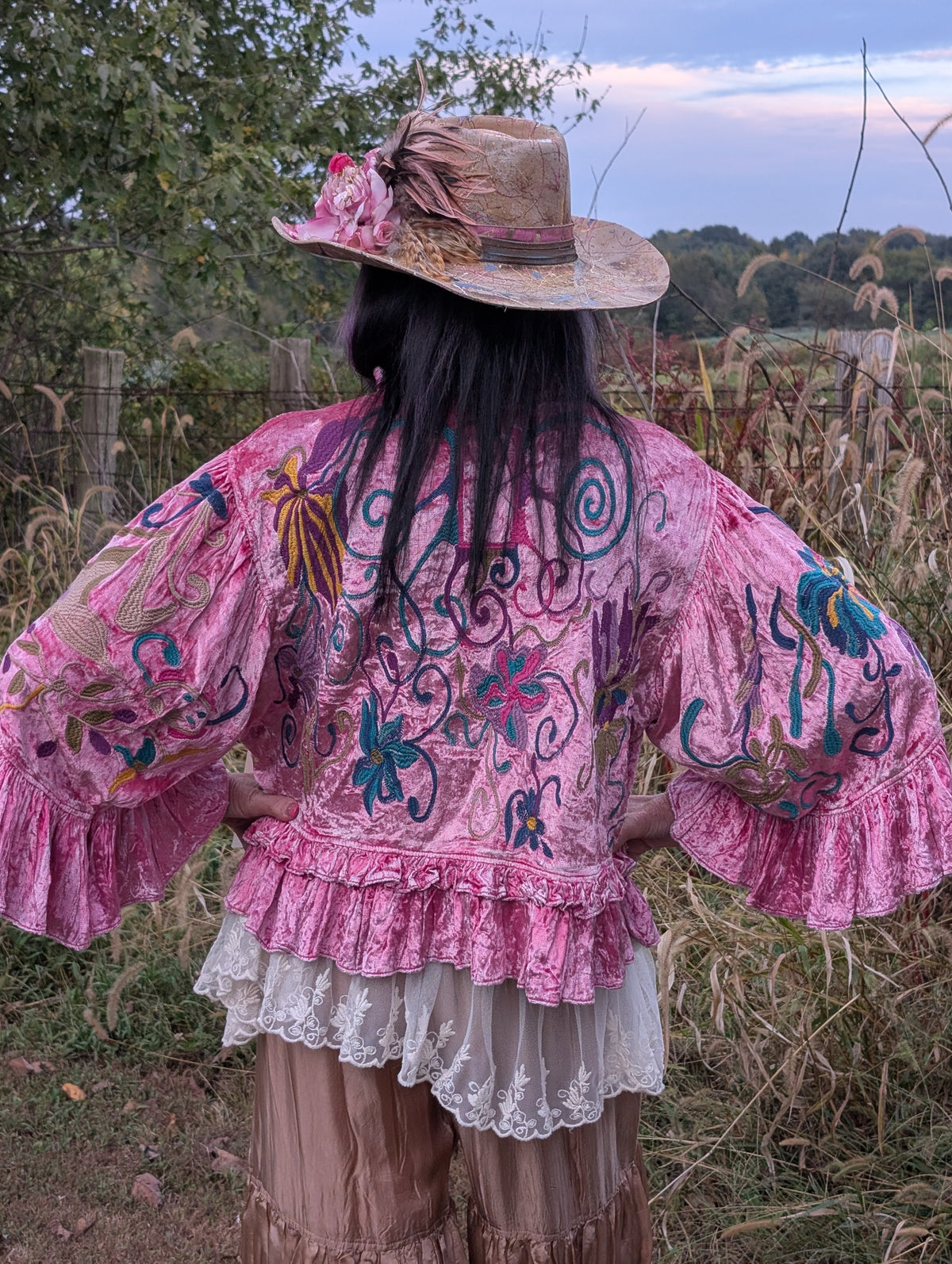 Back view of Fuchsia Fairytale Embroidered Jacket — Felecia Bella by paper lace, showing multicolored floral and scrolling embroidery on fuchsia fabric with a ruffled hem.