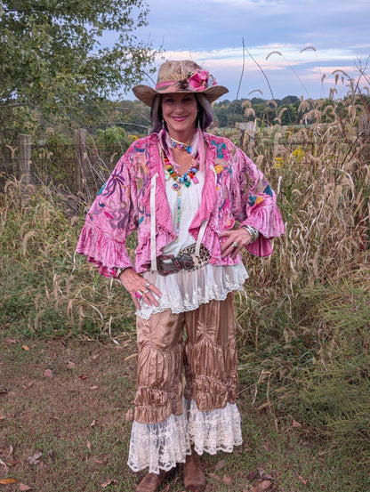 Front styled view of Fuchsia Fairytale Embroidered Jacket — Felecia Bella by paper lace, showing colorful floral embroidery, ruffled edges and flared ruffled cuffs.