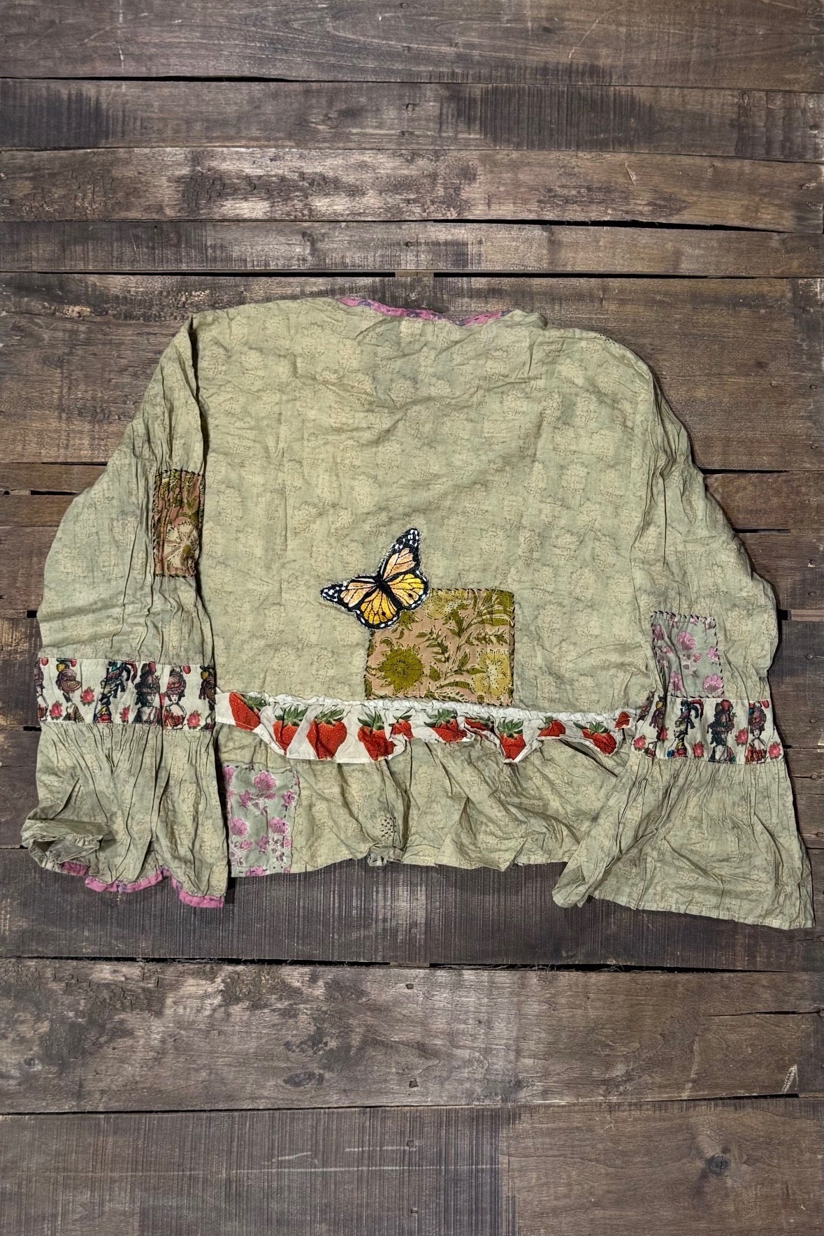 Back of House of Jaded Gypsy Honey Bloom Top in Moss with yellow butterfly detail, floral patches, strawberry ruffle and flared cuffs