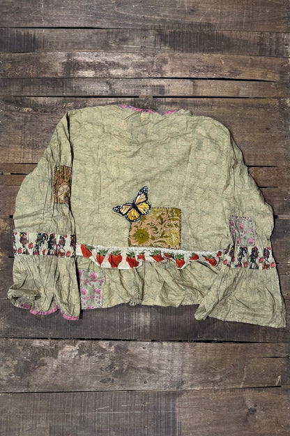 Back of House of Jaded Gypsy Honey Bloom Top in Moss with yellow butterfly detail, floral patches, strawberry ruffle and flared cuffs