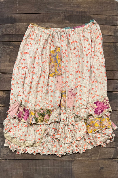 Back of House of Jaded Gypsy Sun Spell Skirt in Canyon Glow with coral floral print, pink and yellow patchwork, tiered ruffles and lace accents