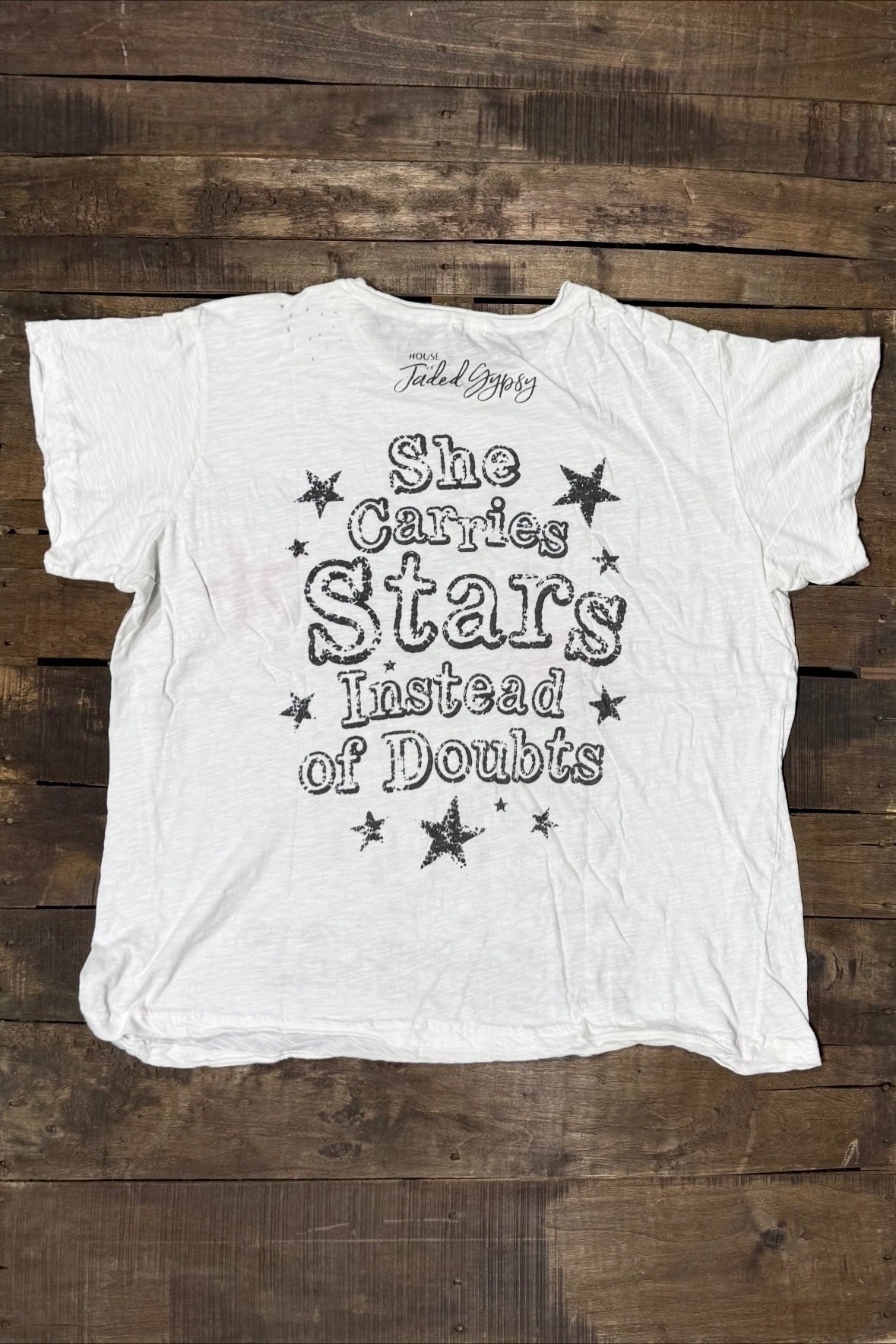 Back of House of Jaded Gypsy Weathered and Worn Tee Superstar with She Carries Stars Instead of Doubts lettering and black stars