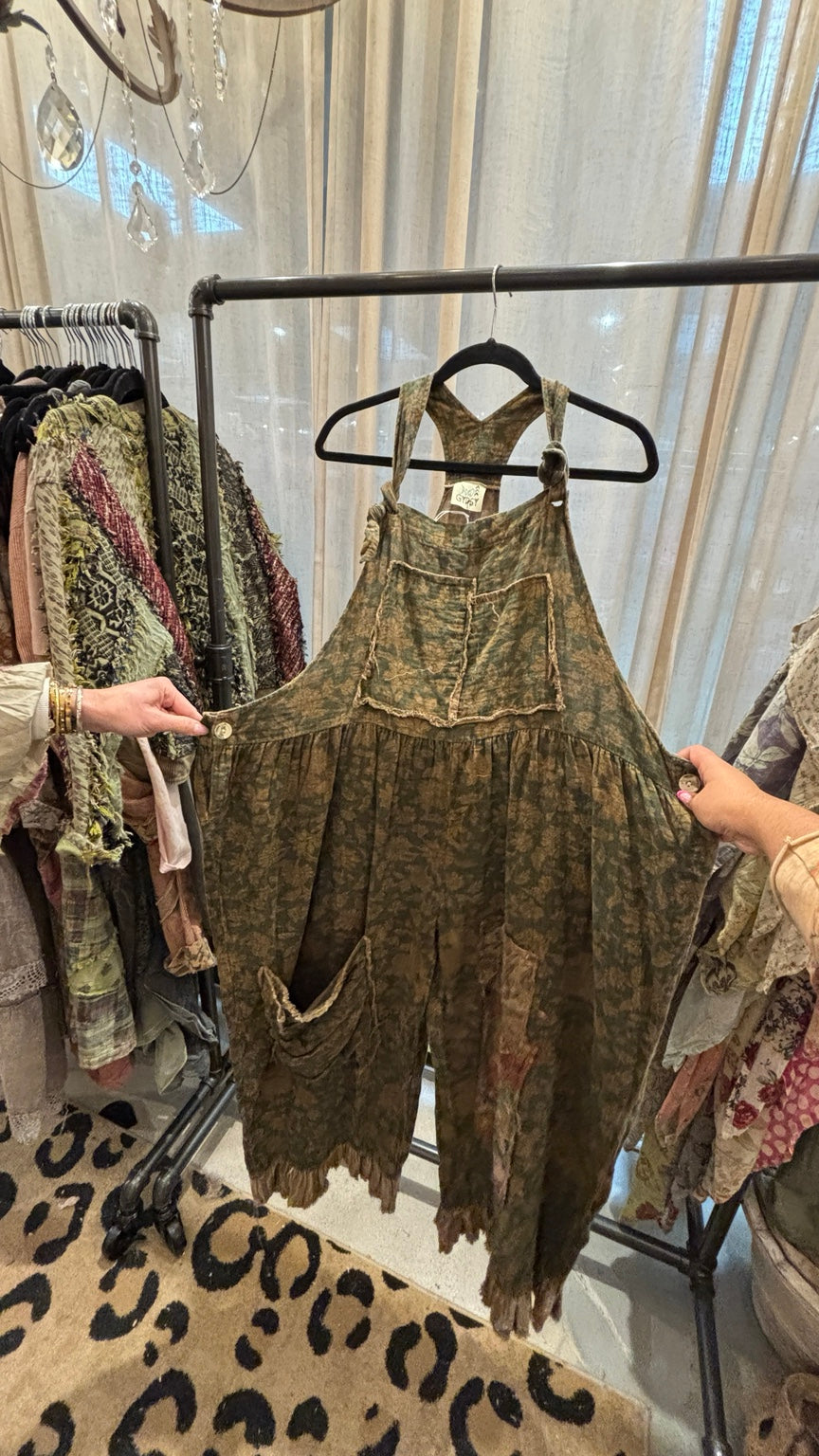 Prairie Views Overalls Sage shown spread out to display roomy legs and floral patch details