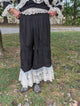 Rambling Rose Lace Pants in Black — front view showing a gathered waist, ruched details, tiered legs and light floral lace hems.