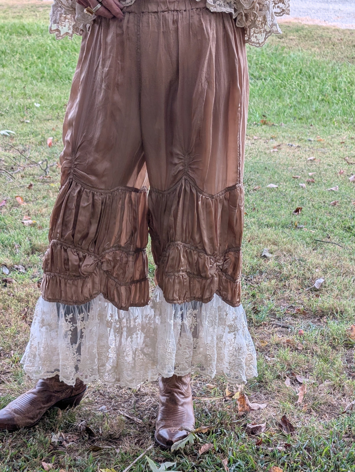 Rambling Rose Lace Pants in Khaki — front view showing a gathered waist, ruched details, tiered legs and light floral lace hems.
