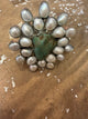 A Rare Bird statement cuff with a green-blue center stone, iridescent white accents, and silver-tone setting