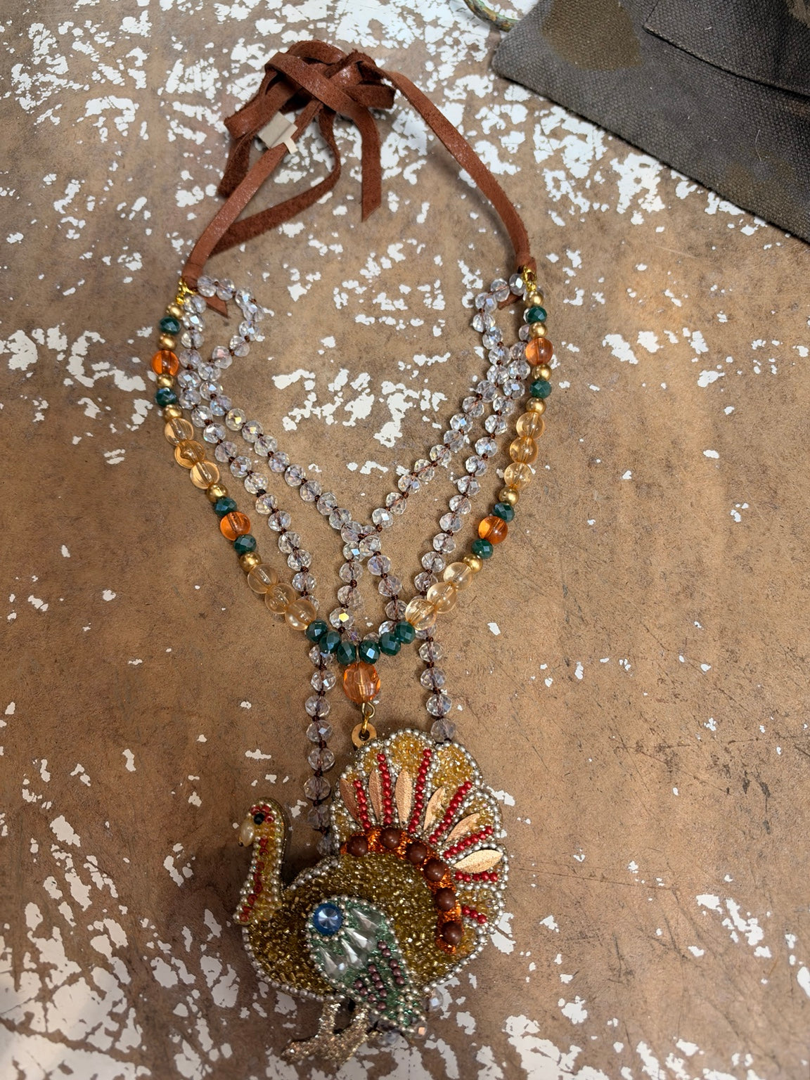 A Rare Bird jeweled turkey pendant necklace with layered beads and brown ties