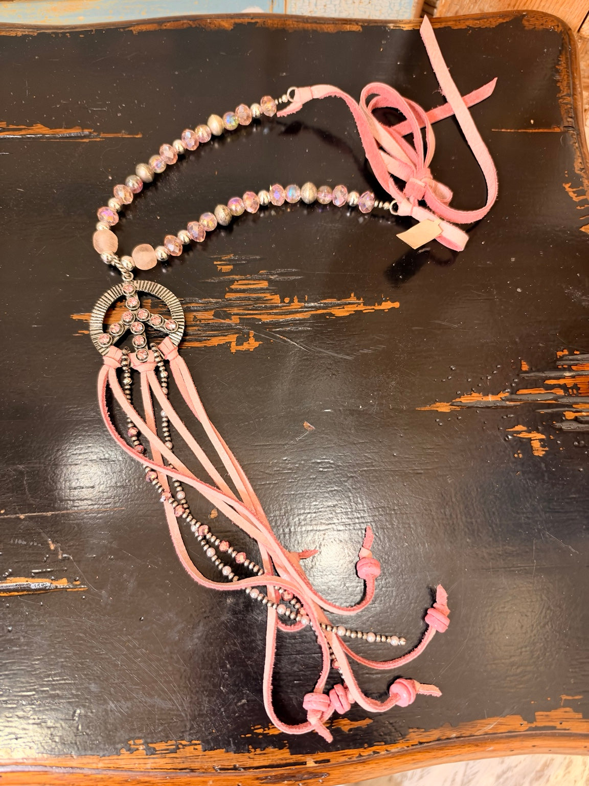 A Rare Bird pink beaded peace sign necklace with pink tassels and silver tone accents