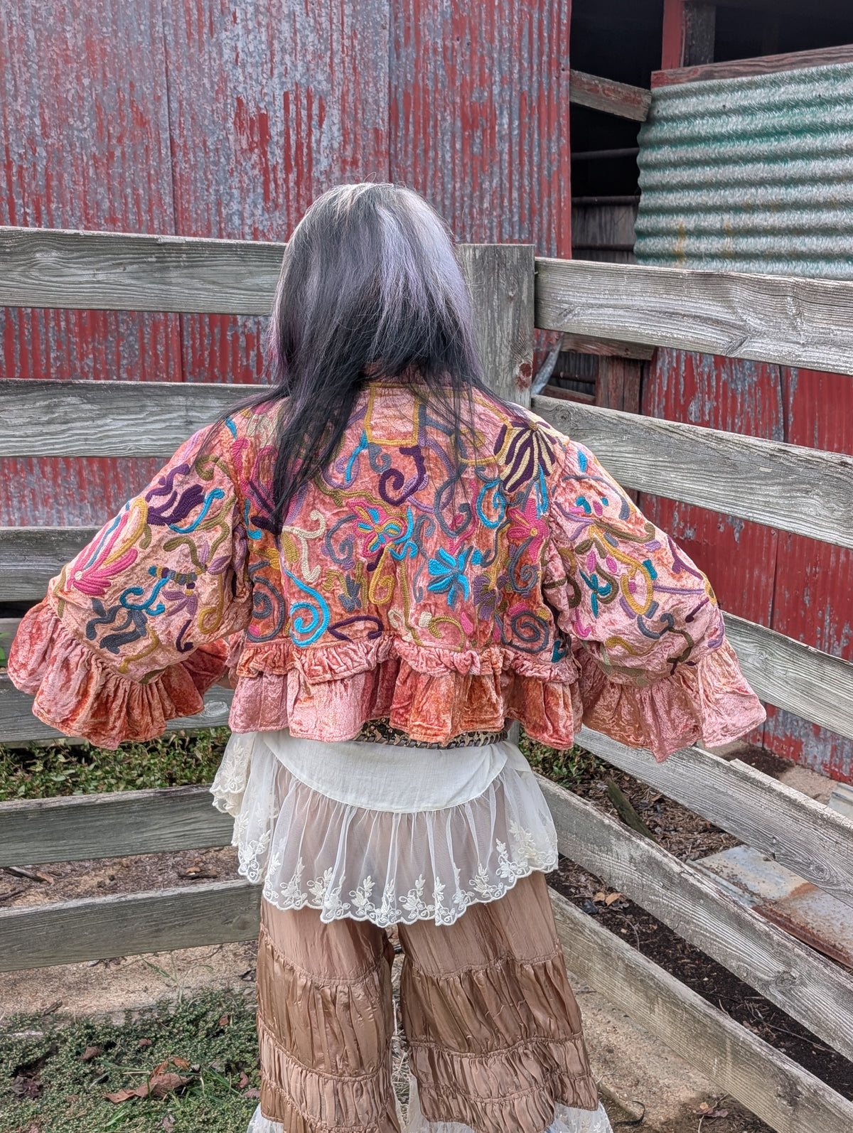 Back view of the embroidered side of Rosewater Rhapsody Reversible Jacket — Felecia Bella by paper lace, with multicolored floral and scrolling motifs and a ruffled hem.