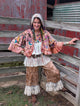 Front styled view of Rosewater Rhapsody Reversible Jacket — Felecia Bella by paper lace, showing colorful embroidery on a rosy background and ruffled sleeves and hem.