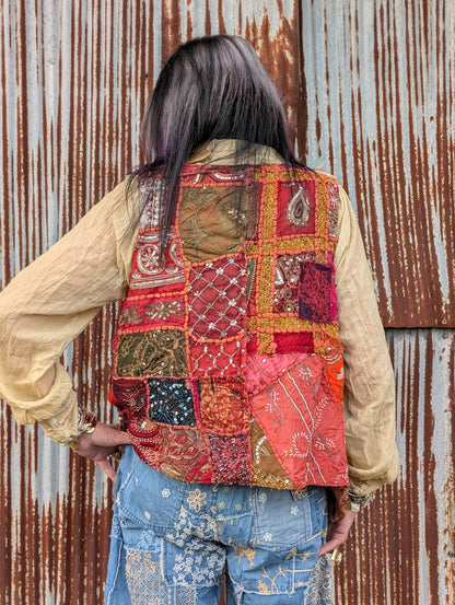 Back view of the Scarlet Caravan Patchwork Vest — Felecia Bella by paper lace, showing multicolored embellished patchwork panels.