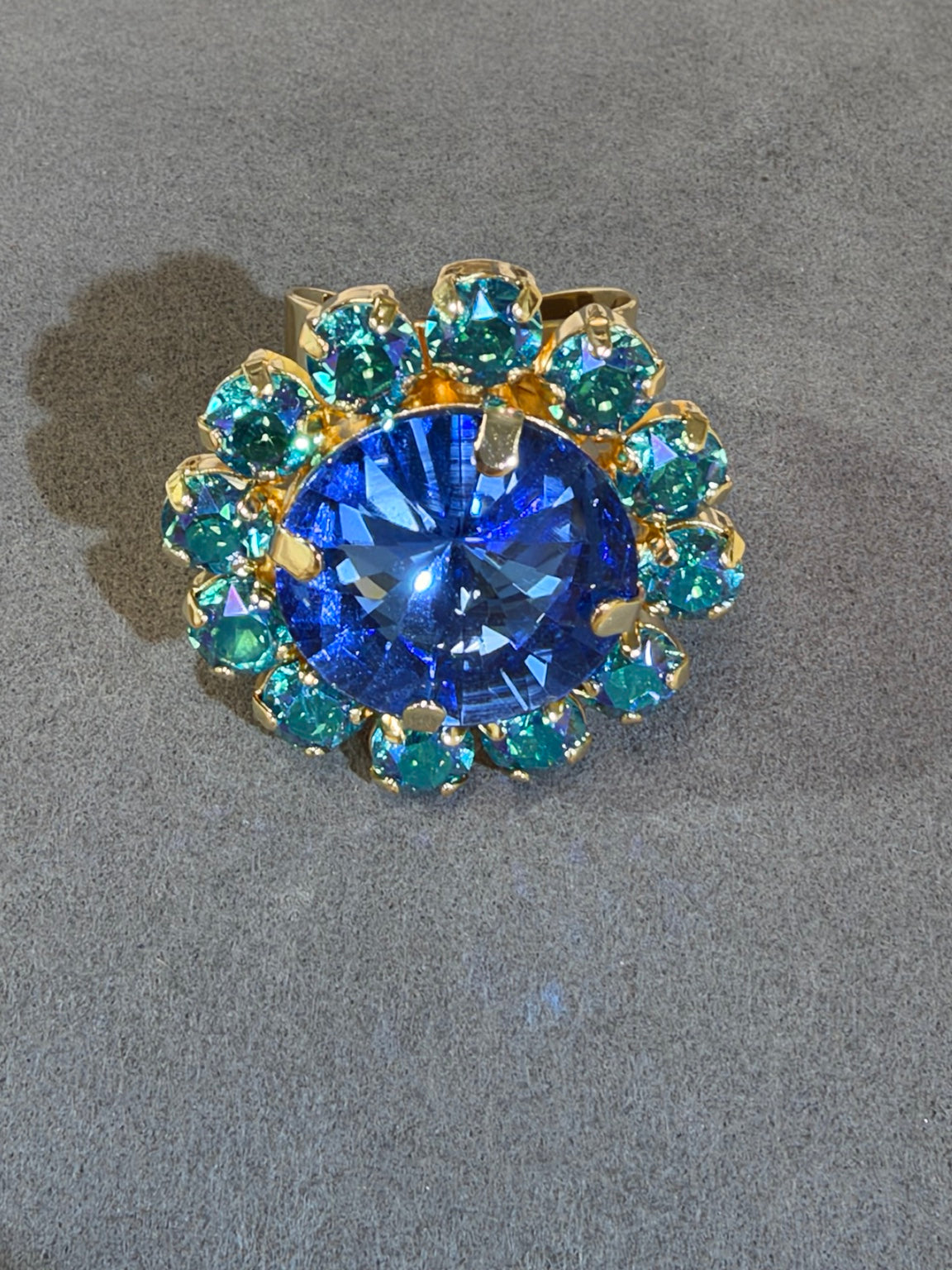 Wafa Aura Halo Ring with sapphire blue center and teal crystal halo in gold-tone setting