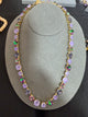 Lavender, smoky purple and green-purple iridescent round crystals in a gold-tone necklace