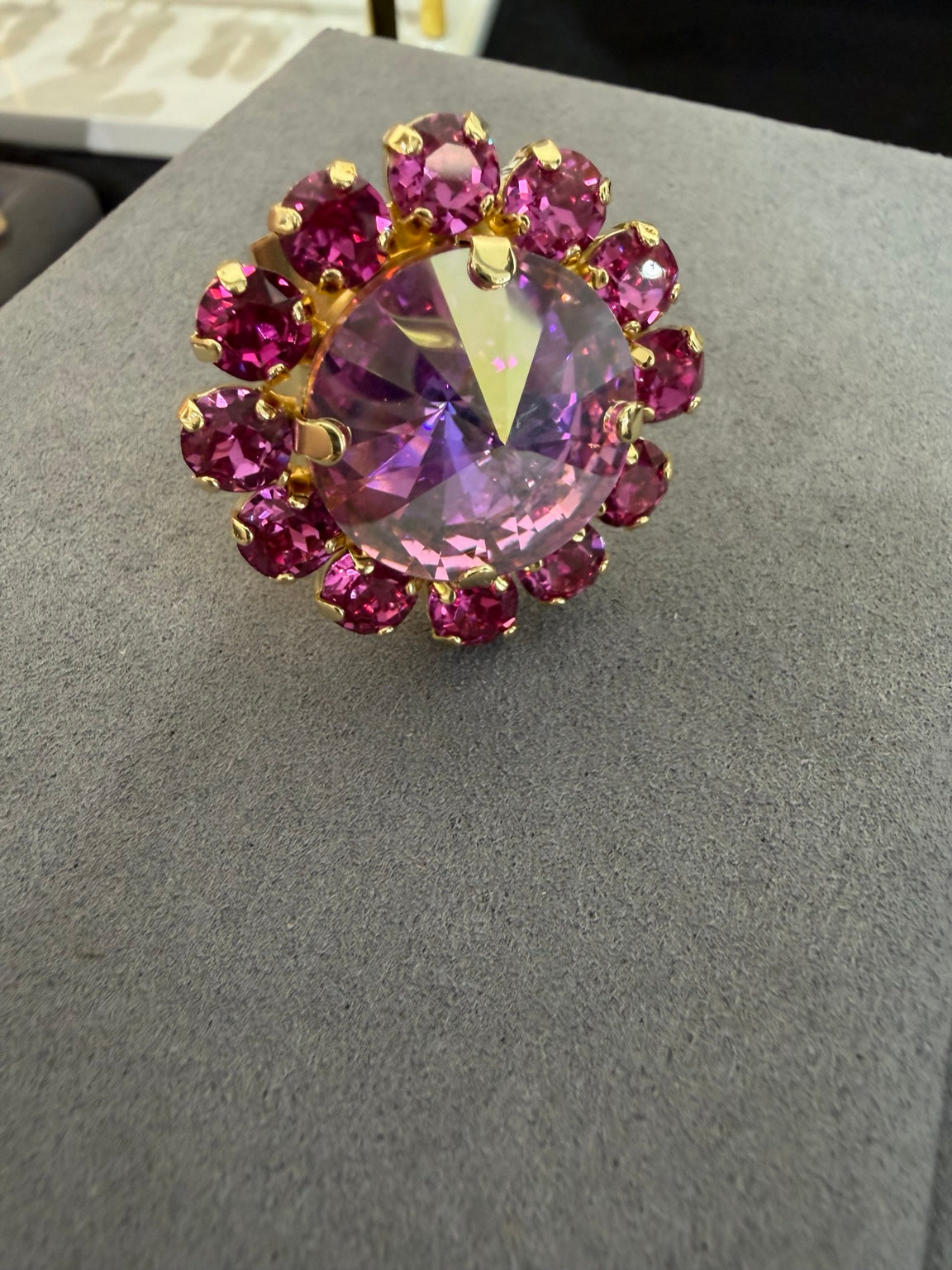 Wafa Pink Aura Halo Ring with a large iridescent pink center surrounded by fuchsia crystals in gold-tone settings