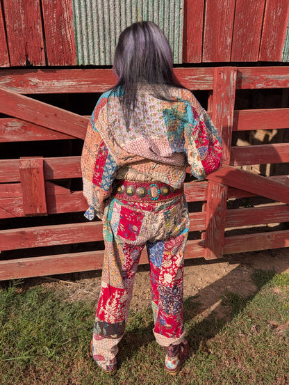 Back view of the Wandering Soul Kantha Jacket styled with coordinating patchwork pants and accessories; jacket hem is lifted in the photo.
