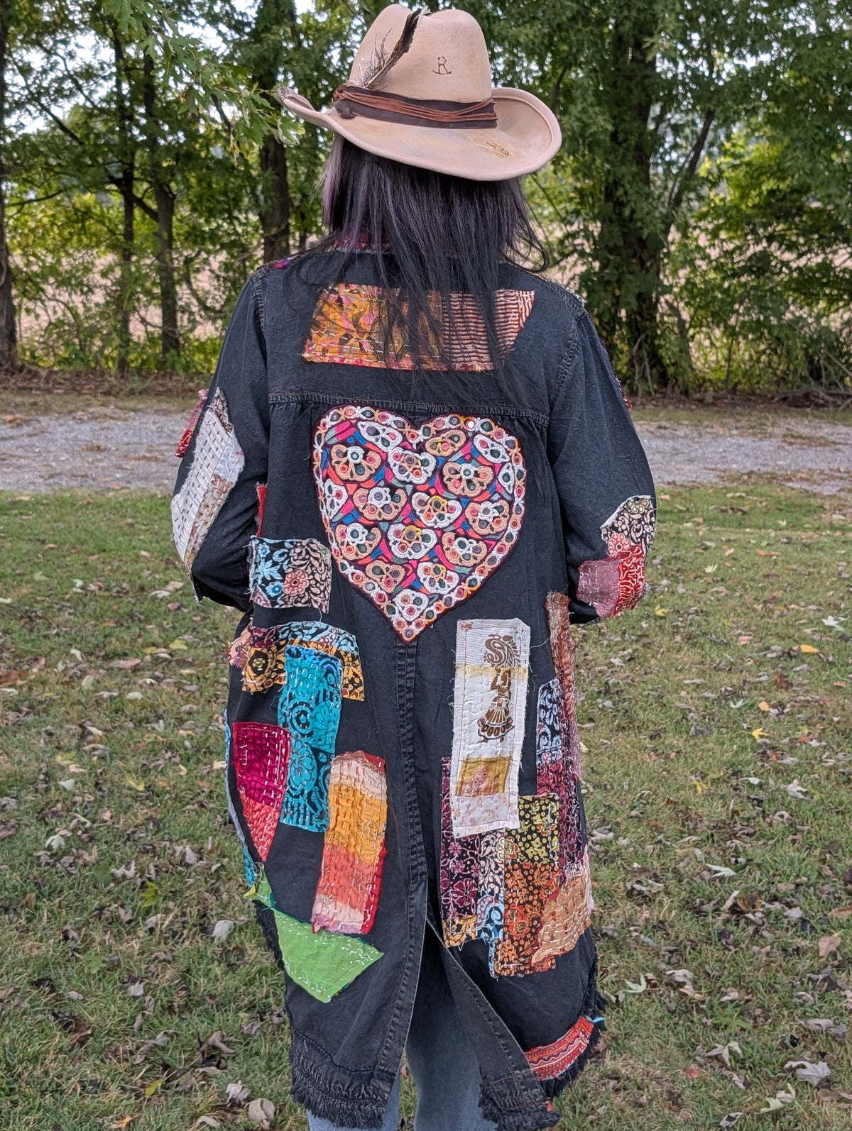 Back view of Wild Heart Wanderer Duster — Felecia Bella by paper lace, showing a large colorful embroidered heart, patchwork panels and fringed hem.