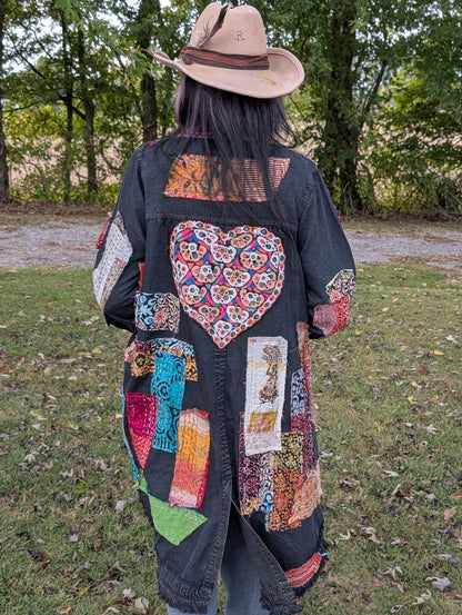 Back view of Wild Heart Wanderer Duster — Felecia Bella by paper lace, showing a large colorful embroidered heart, patchwork panels and fringed hem.